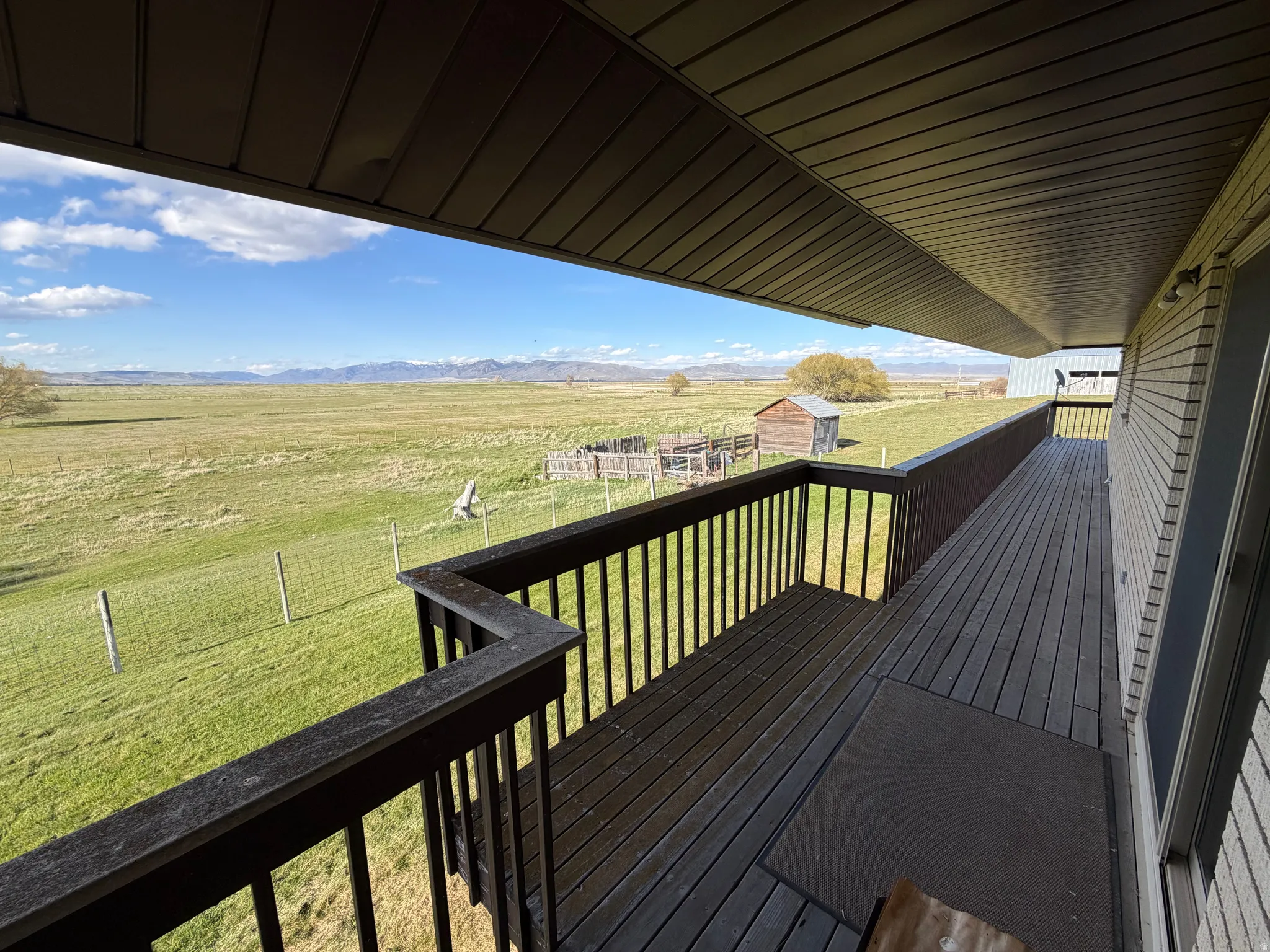 Wooden terrace with a rural view and an outbuilding