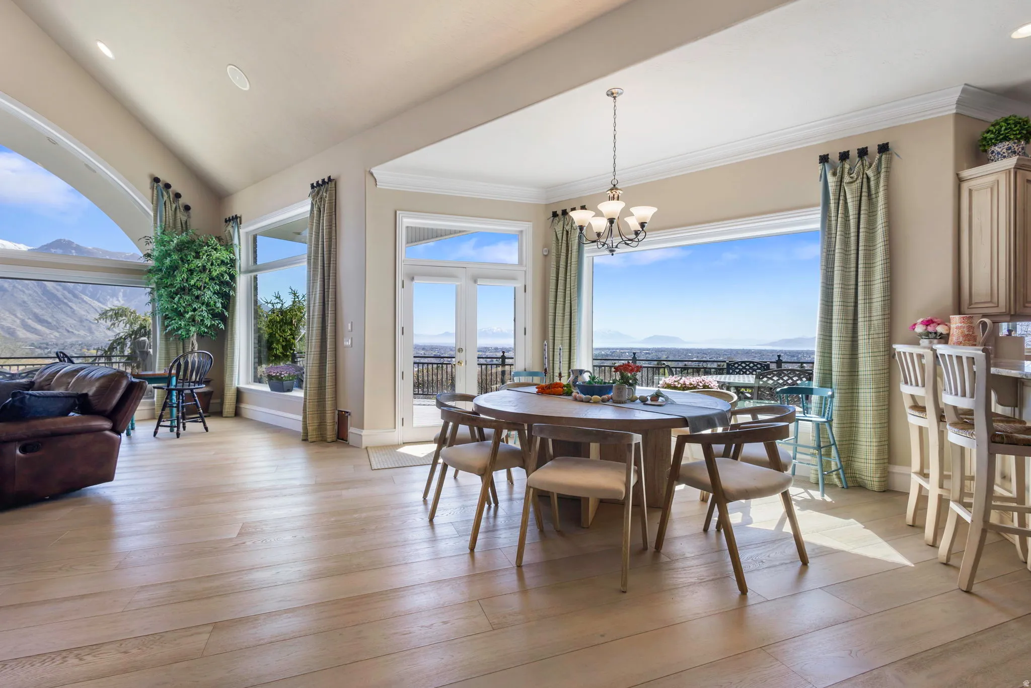Dining area featuring healthy amount of natural light, light wood-style floors, suspended lighting, crown molding, and a mountain view