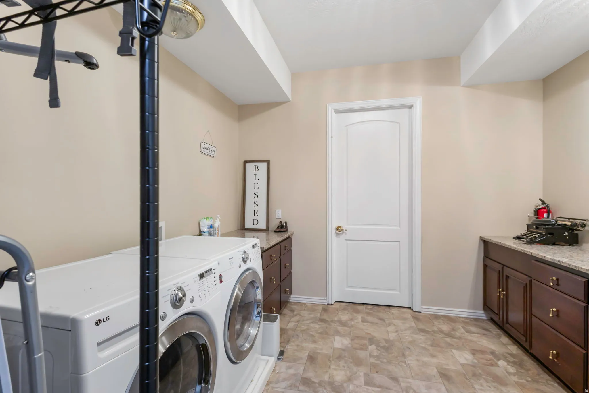 Laundry area featuring stone finish flooring and washer and clothes dryer
