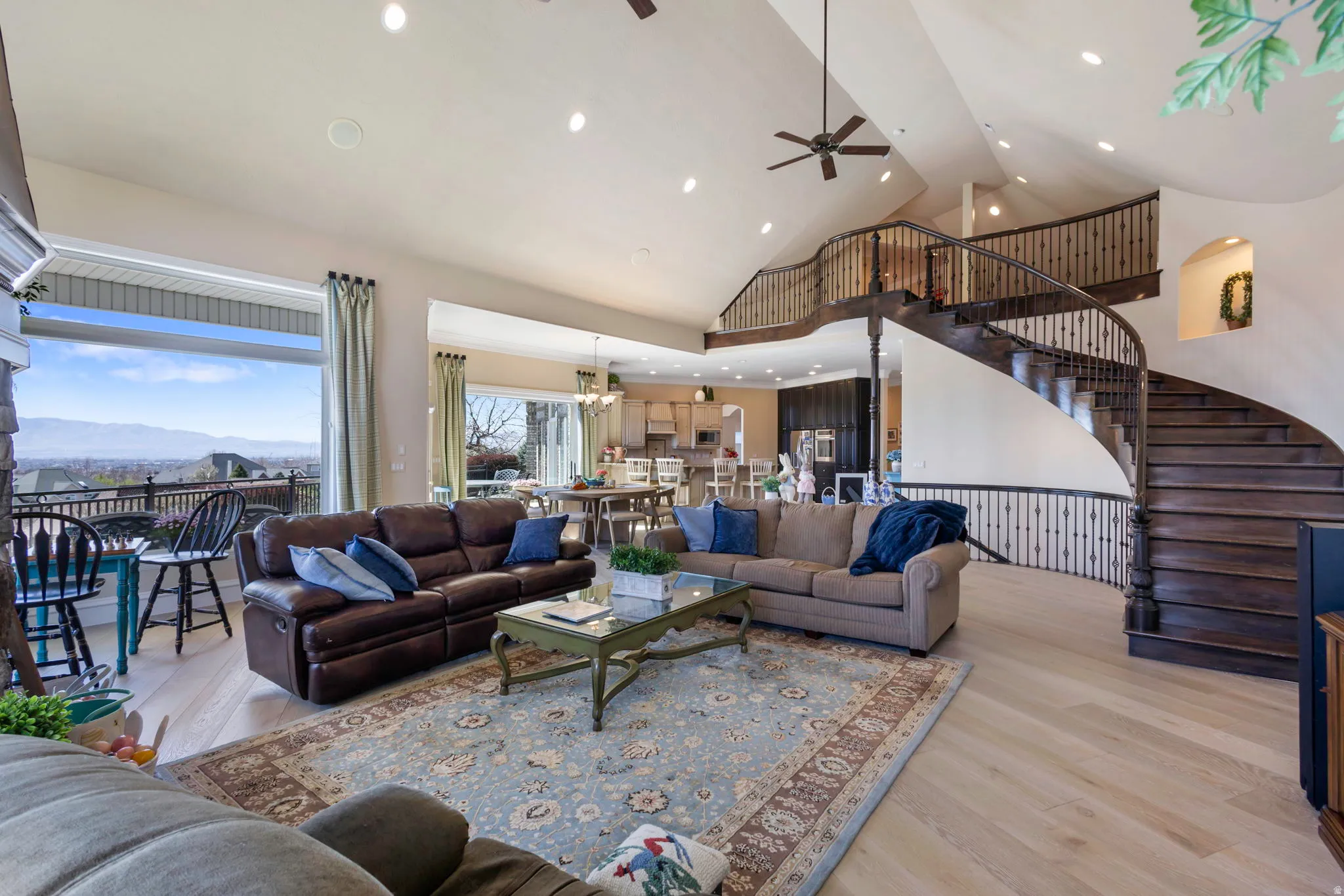 Living room with light wood-style floors, a mountain view, ceiling fan, recessed lighting, and vaulted ceiling