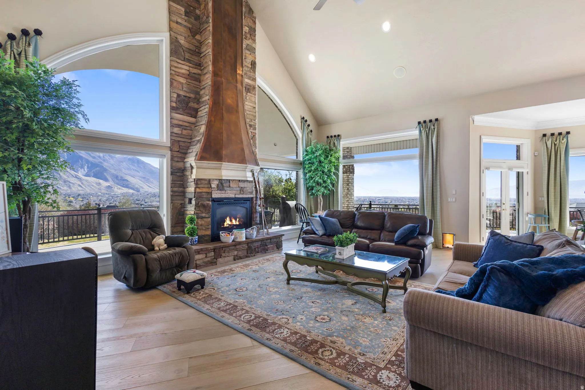 Living area featuring vaulted ceiling, light wood finished floors, recessed lighting, a fireplace, and a ceiling fan