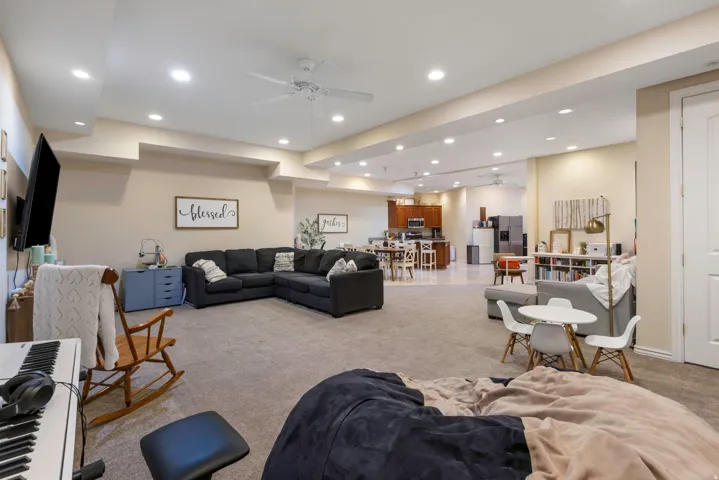 Living room with a ceiling fan, carpet flooring, and recessed lighting