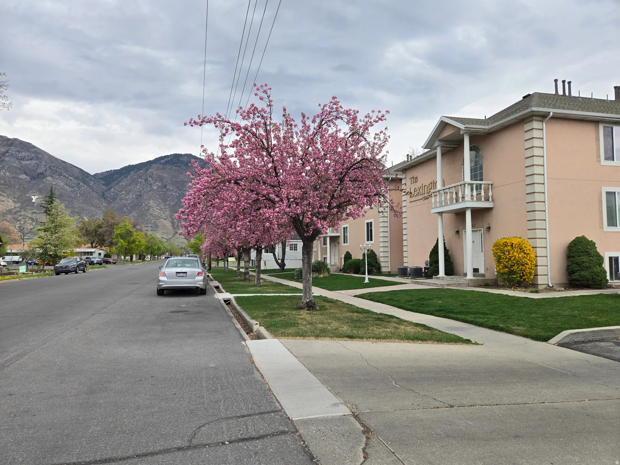 View of asphalt road featuring a mountain view and sidewalks