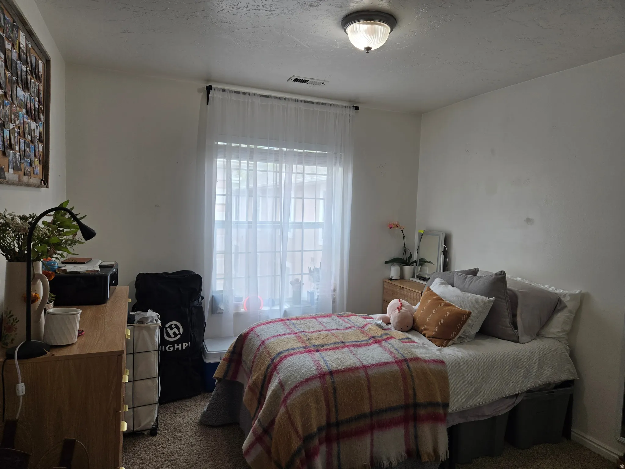Bedroom with dark colored carpet and a textured ceiling