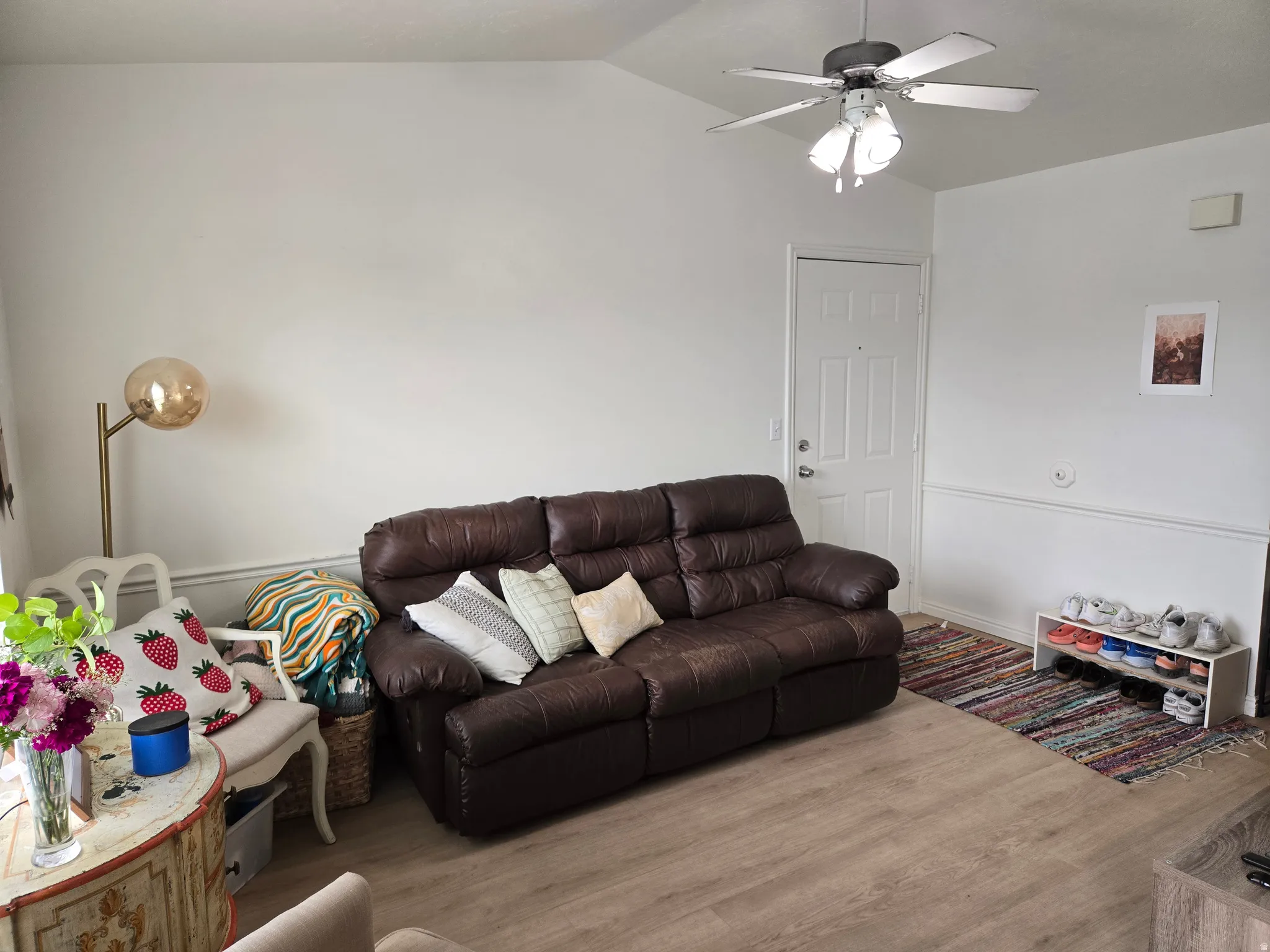Living room featuring vaulted ceiling, wood finished floors, and ceiling fan