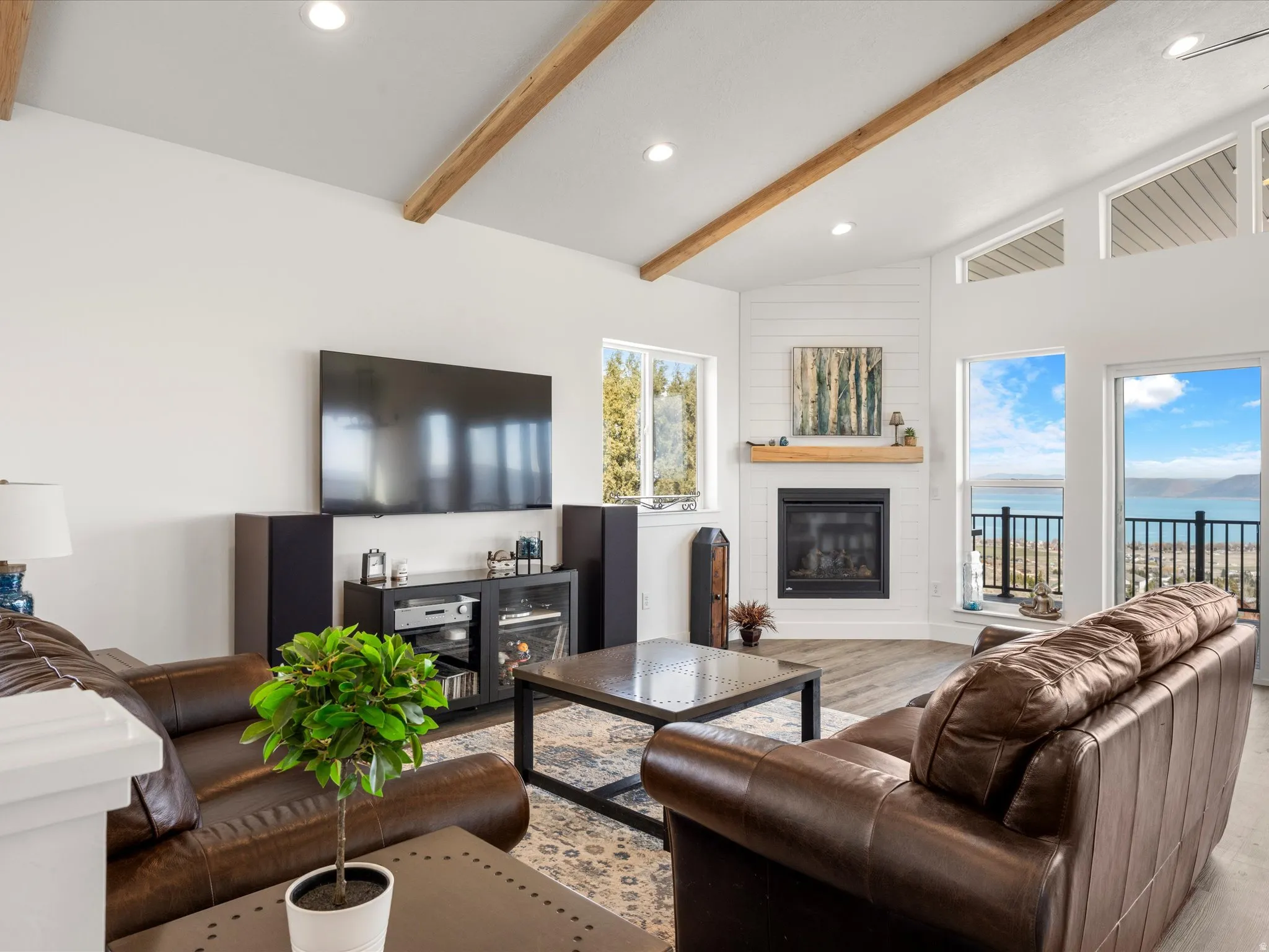 Living area featuring a large fireplace, vaulted ceiling, light wood-type  flooring, and recessed lighting