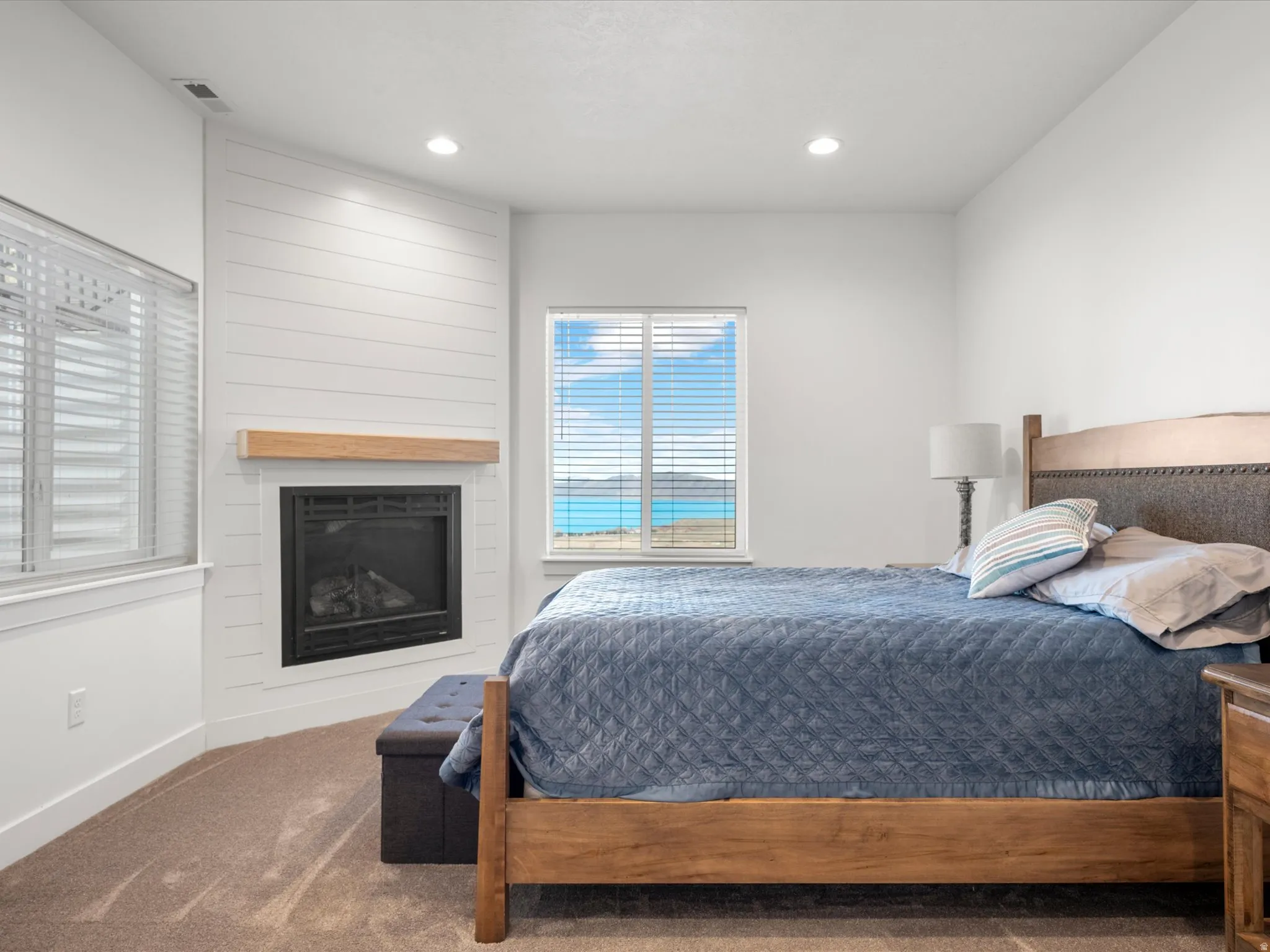 Bedroom featuring carpet flooring, a large fireplace, and recessed lighting
