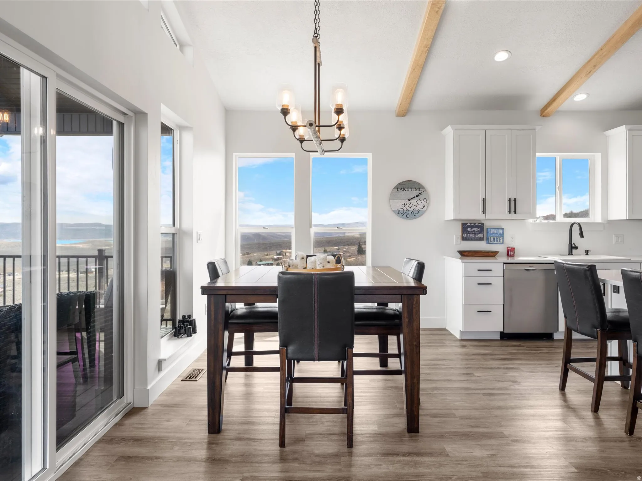 Dining room with hanging lights, dark wood-type flooring, beamed ceiling, and plenty of natural light