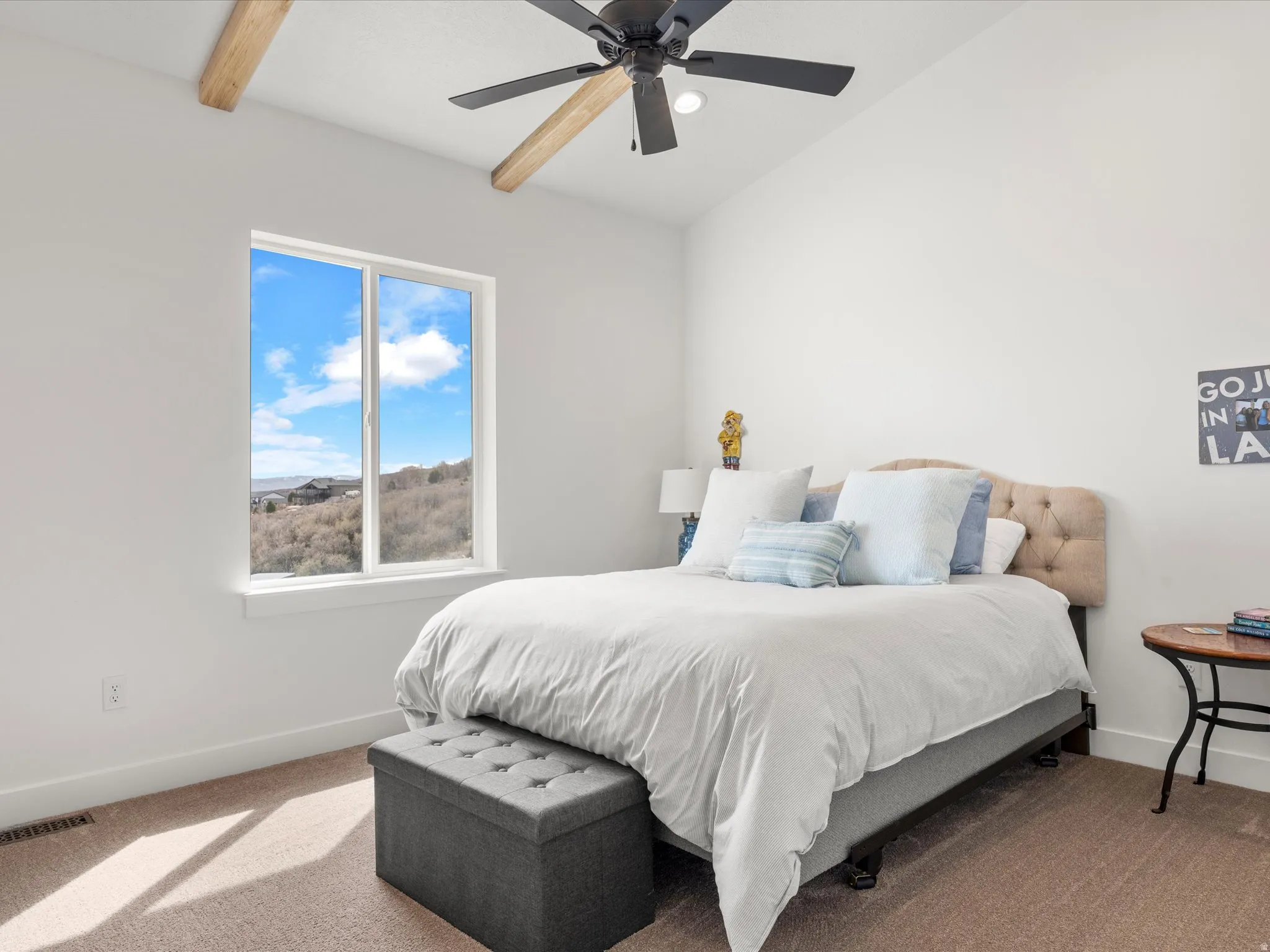 Carpeted bedroom featuring ceiling fan and vaulted ceiling