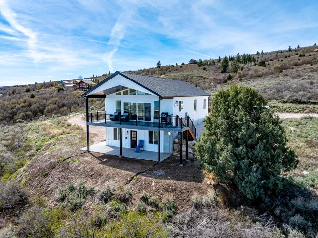 Back of house with a patio area and a view of countryside