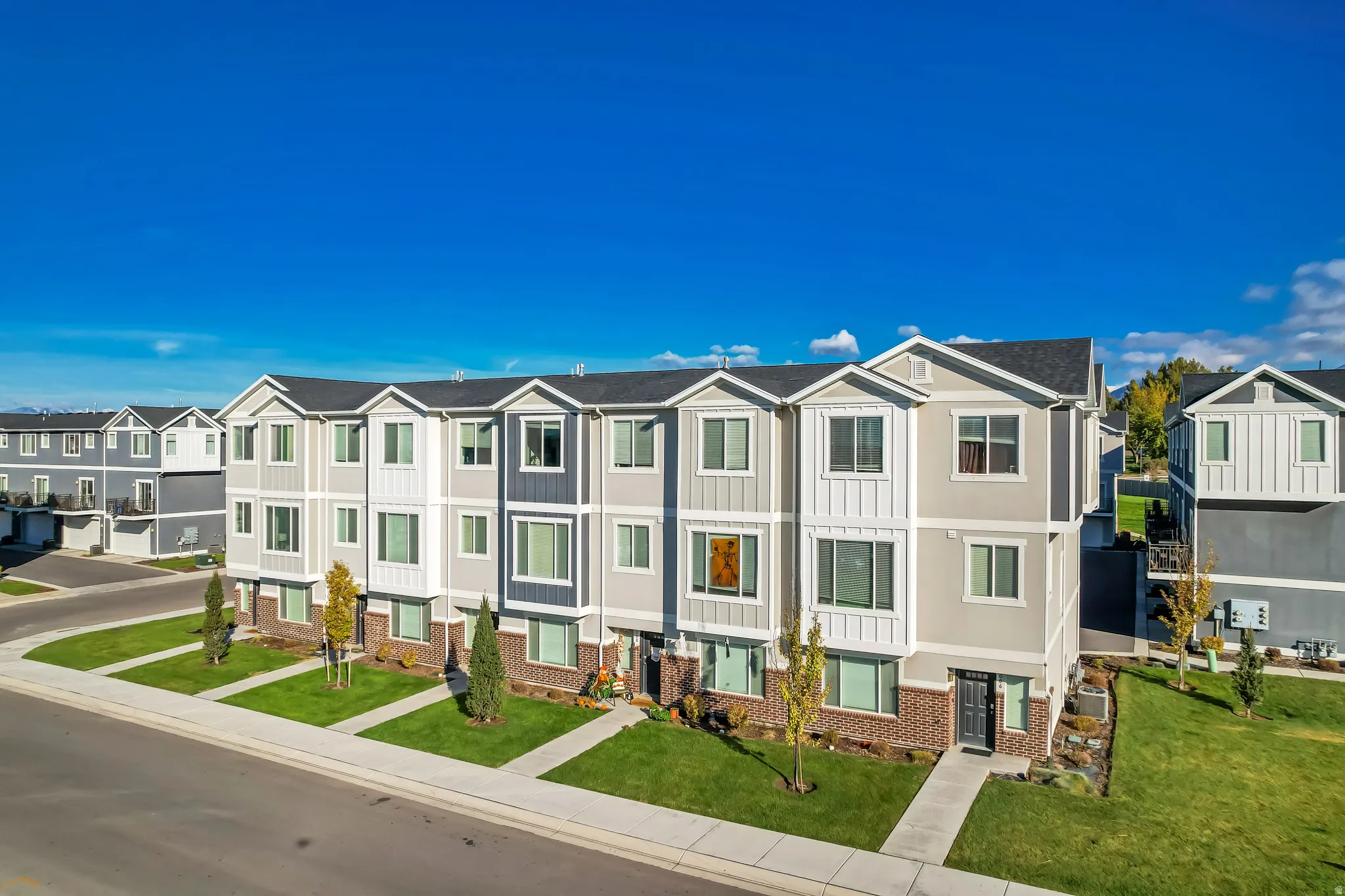 View of front facade featuring a residential view, brick siding, board and batten siding, and a front lawn