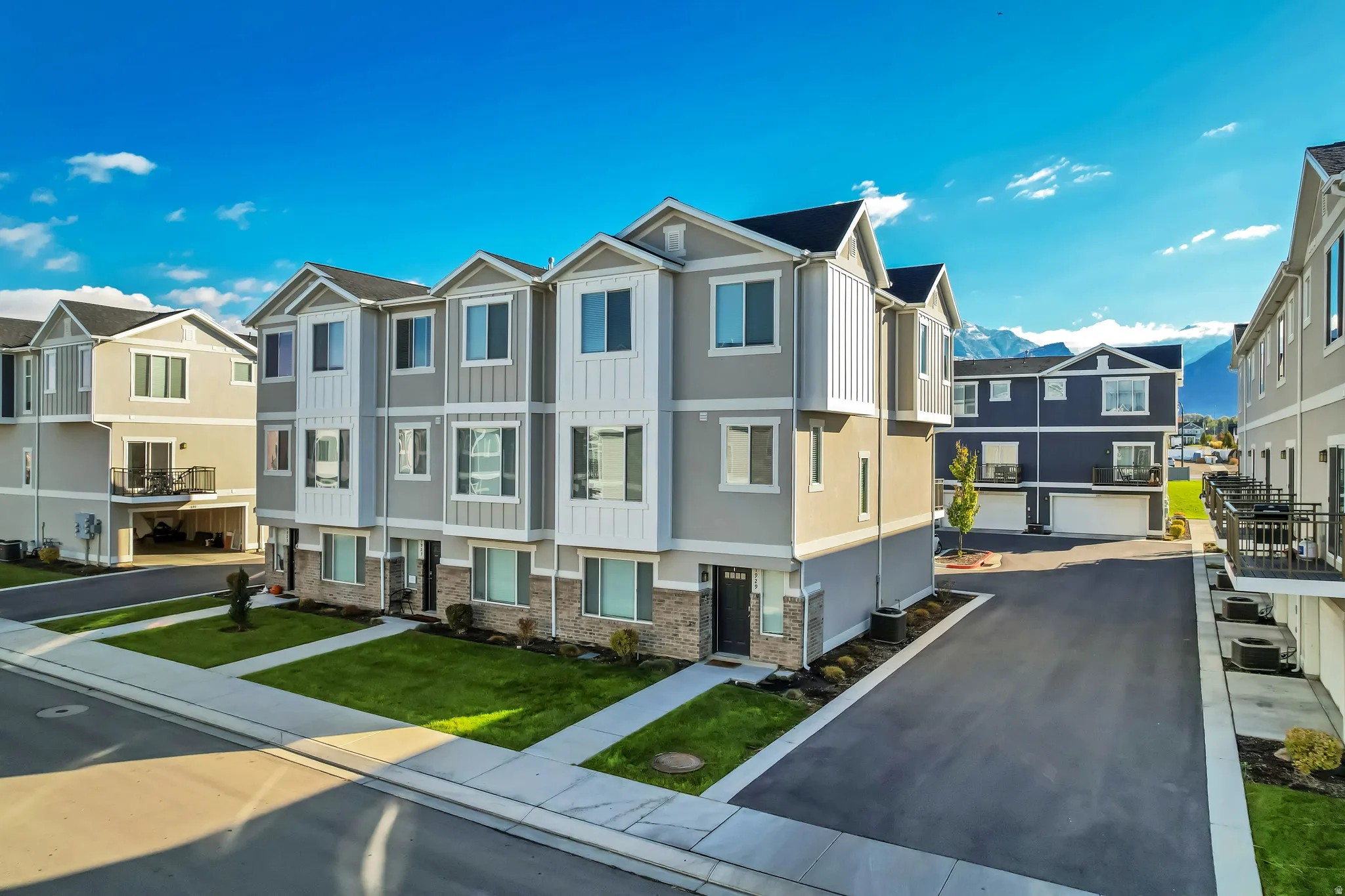 View of front of property with a residential view, brick siding, a mountain view and a front lawn