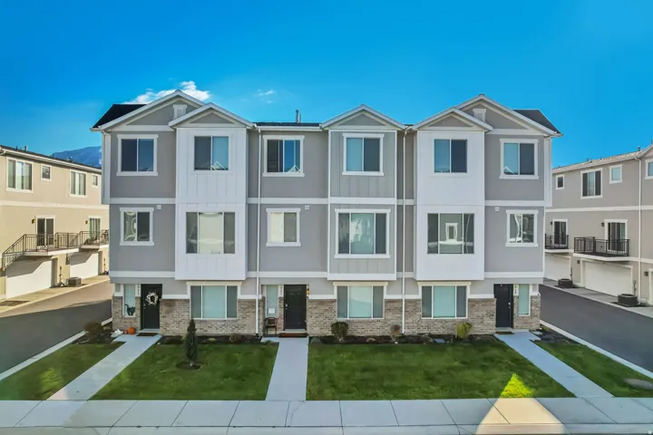View of front of property with a residential view, brick siding, a mountain view and a front lawn