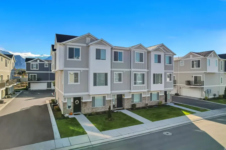 View of front of property with a residential view, brick siding, a mountain view and a front lawn