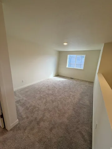 Carpeted room with recessed lighting and a single window