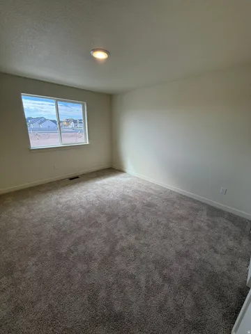 Neutral tone walls, recessed lighting, and grey textured carpet
