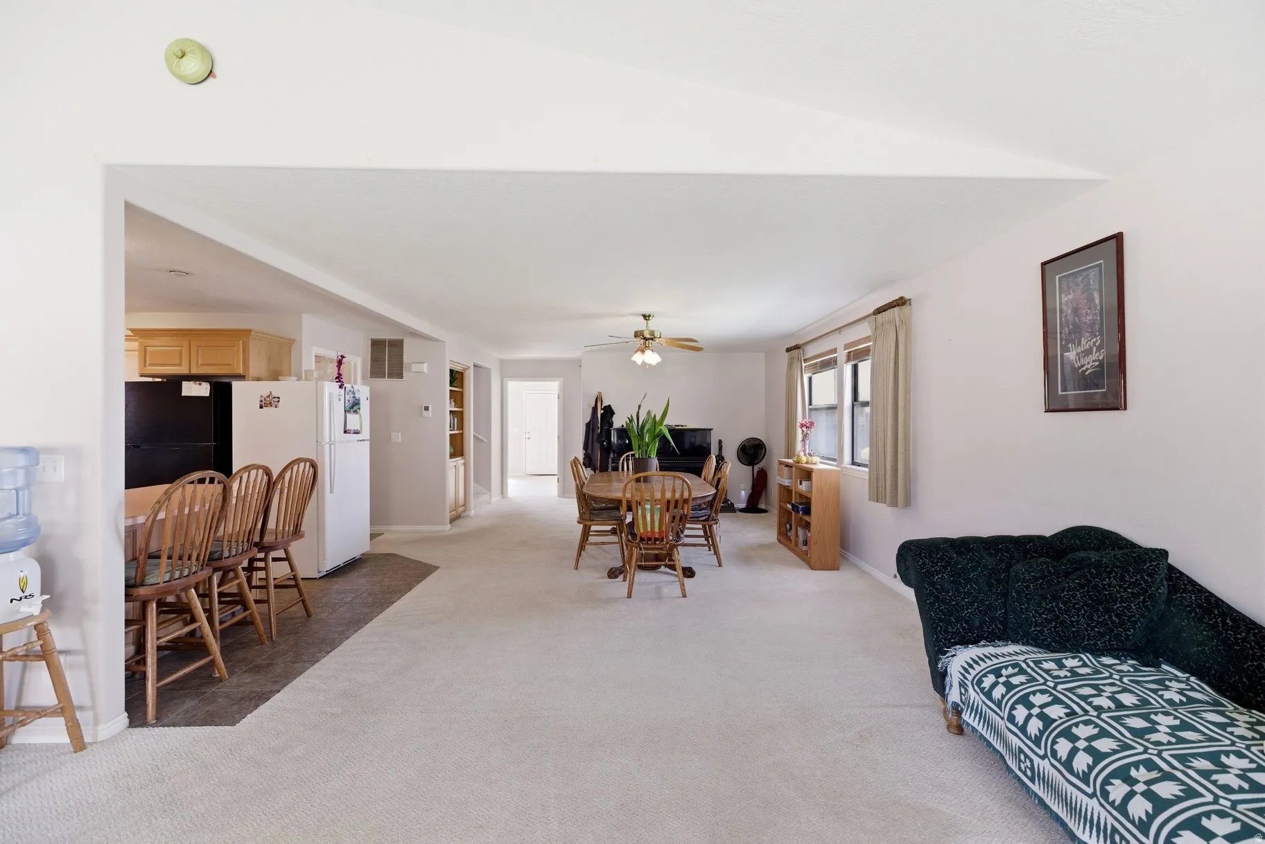 Dining room featuring light carpet and a ceiling fan