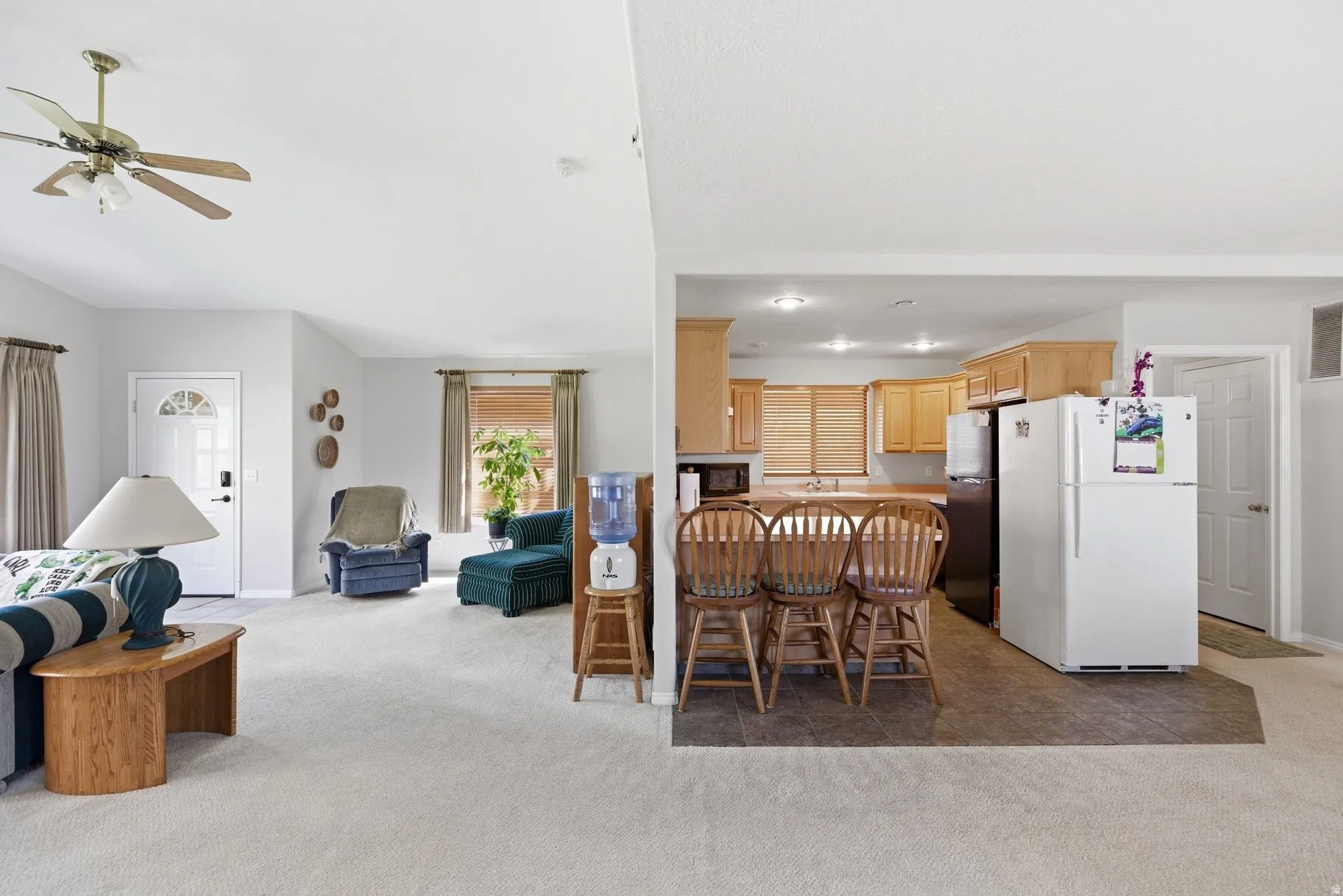 Dining space with light colored carpet and a ceiling fan