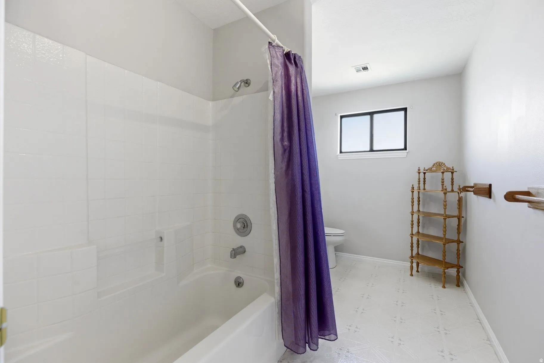 Full bath with light flooring and shower / tub combo