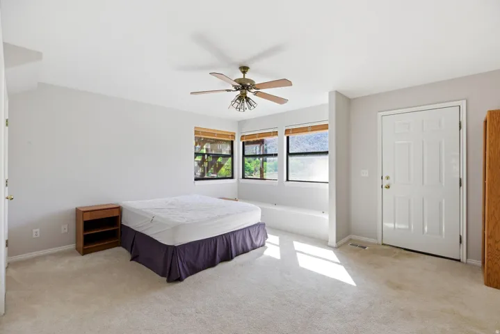 Bedroom featuring light carpet and a ceiling fan