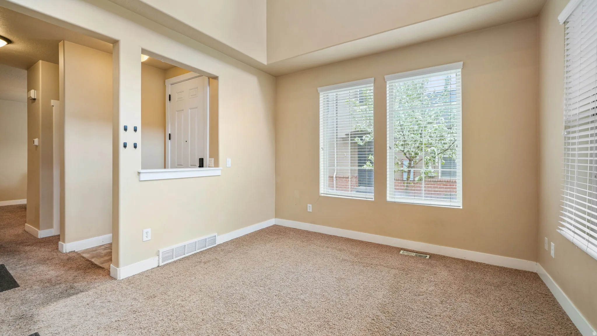 Spare room featuring light colored carpet and baseboards