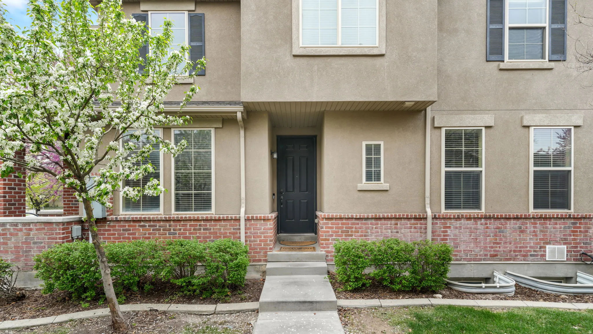 View of exterior entry featuring stucco siding and brick siding