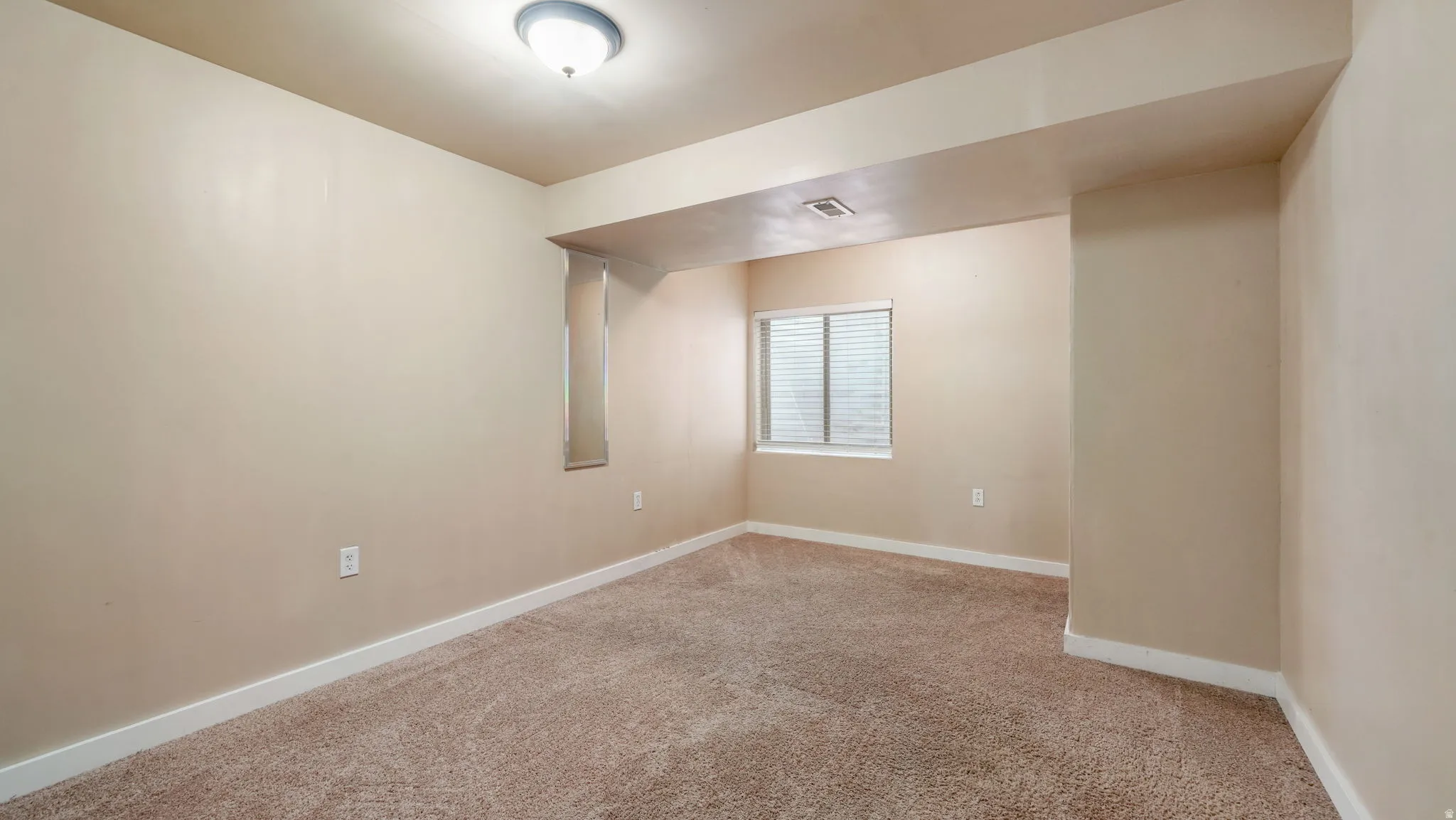 Unfurnished room featuring baseboards and light colored carpet