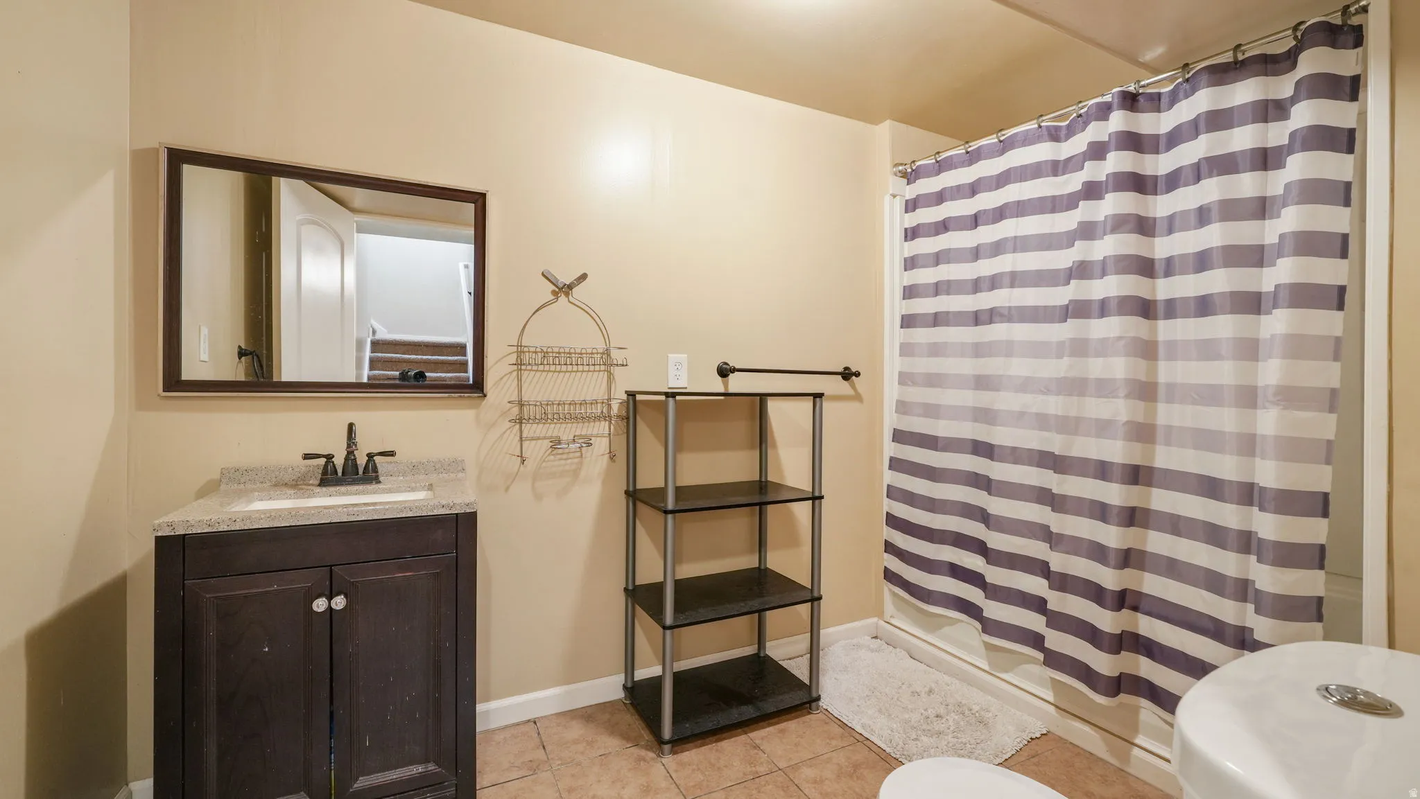 Full bathroom featuring vanity, a stall shower, and light tile patterned flooring