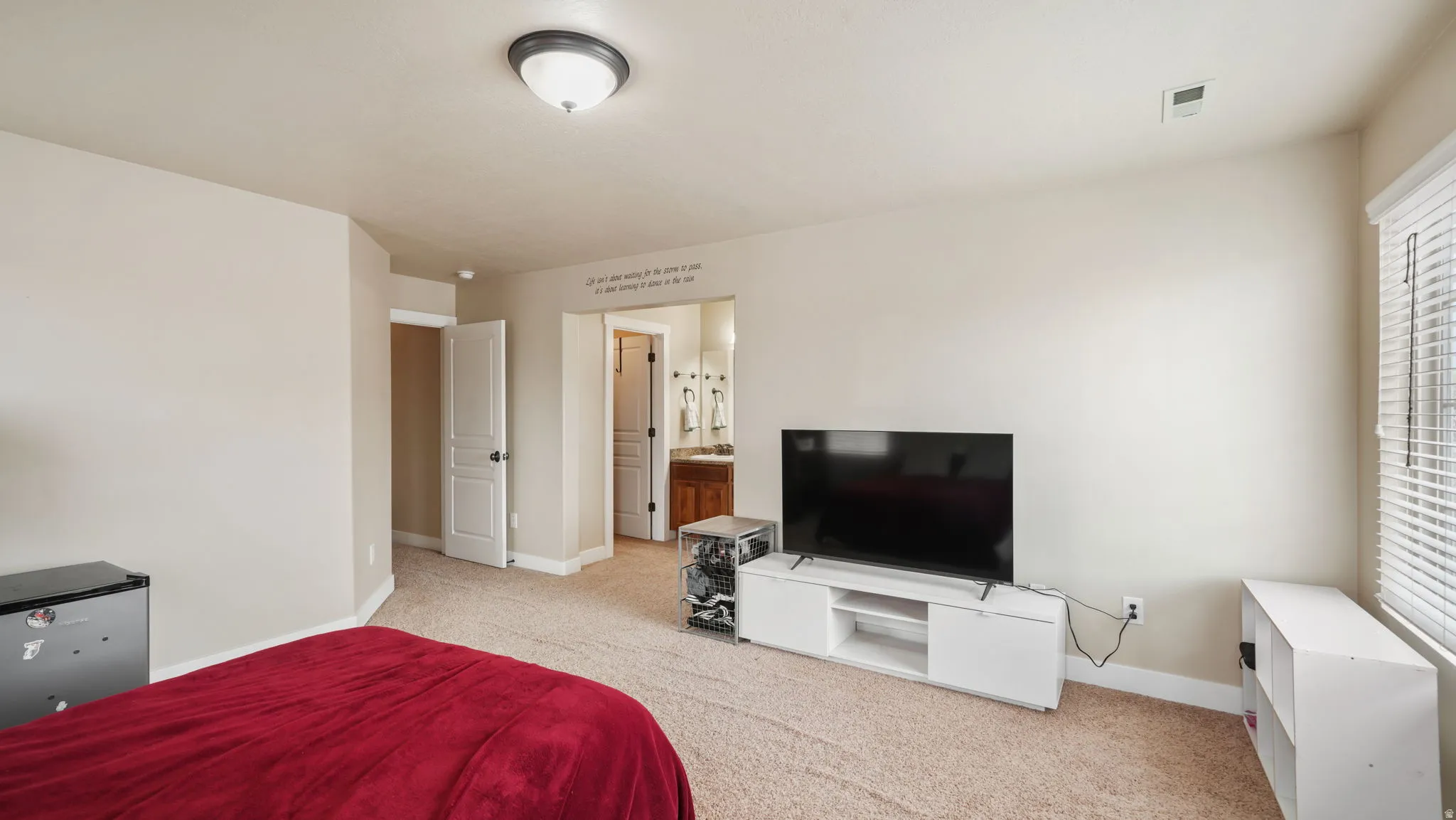 Bedroom with light carpet and ensuite bath