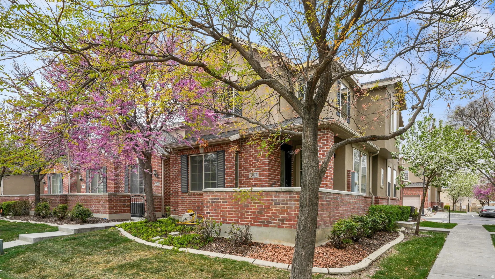 View of side of property featuring brick siding and a yard