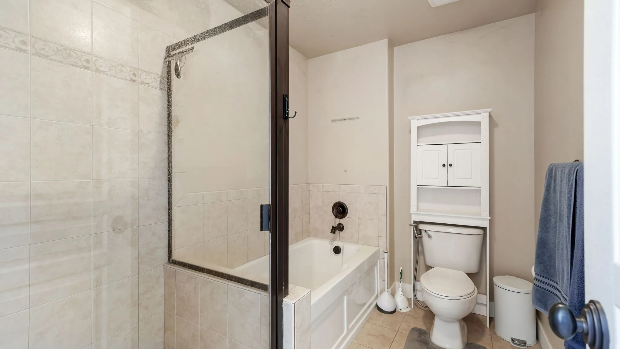 Bathroom with a garden tub, a shower stall, and light tile patterned floors