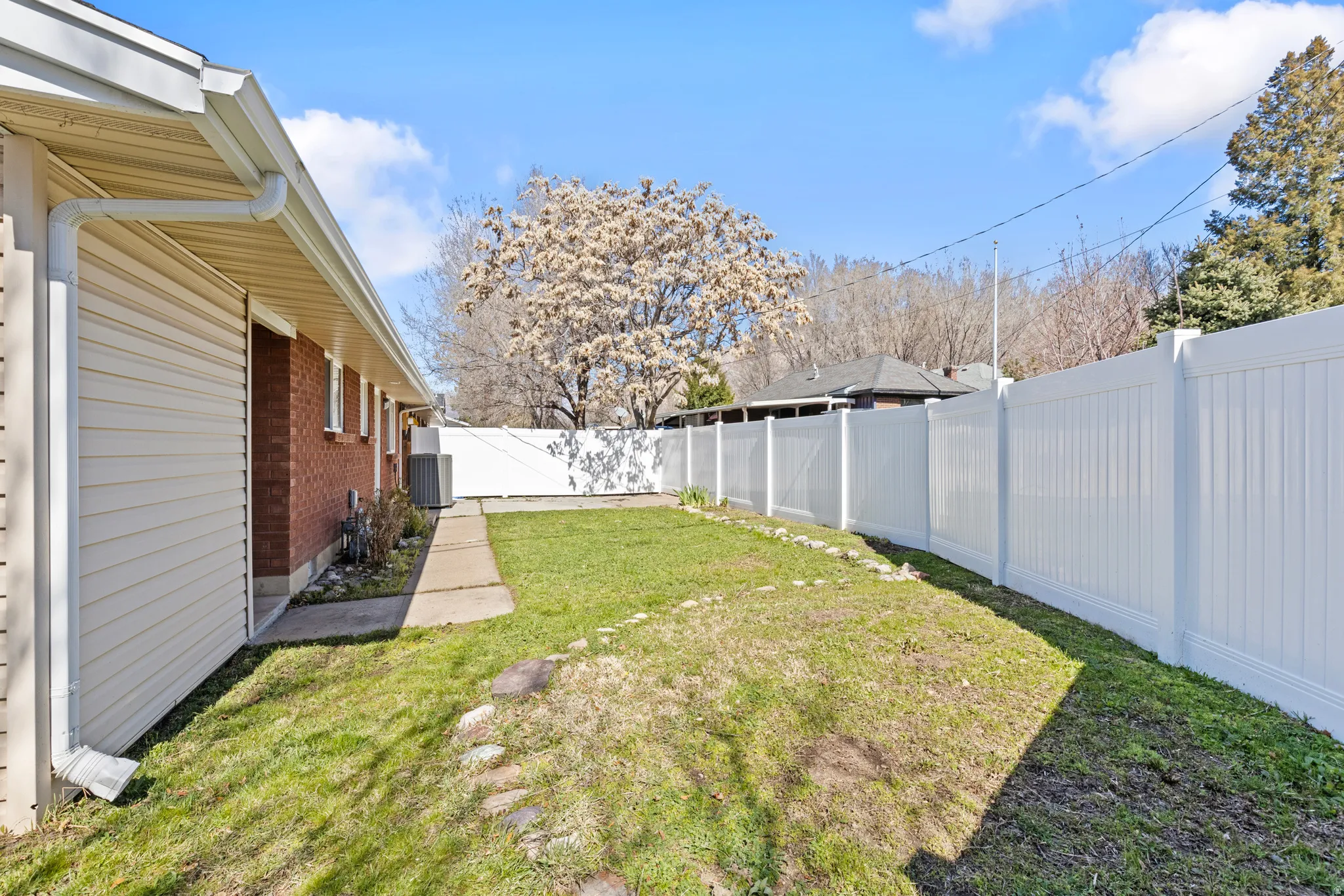 View of fully fenced backyard, private to each duplex with a fence between them.  Sprinkler system disarmed to conserve water.
