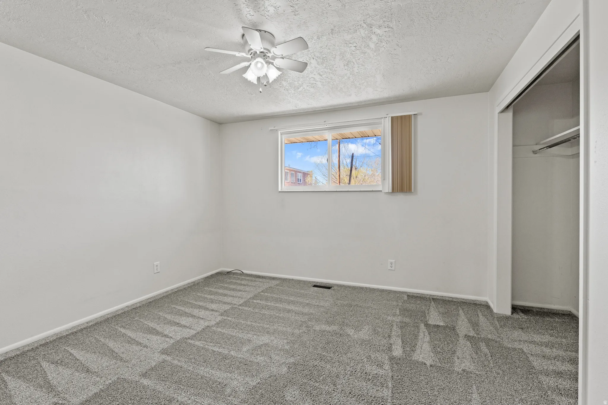 #813 Bedroom with a closet, ceiling fan, carpet floors, and a textured ceiling