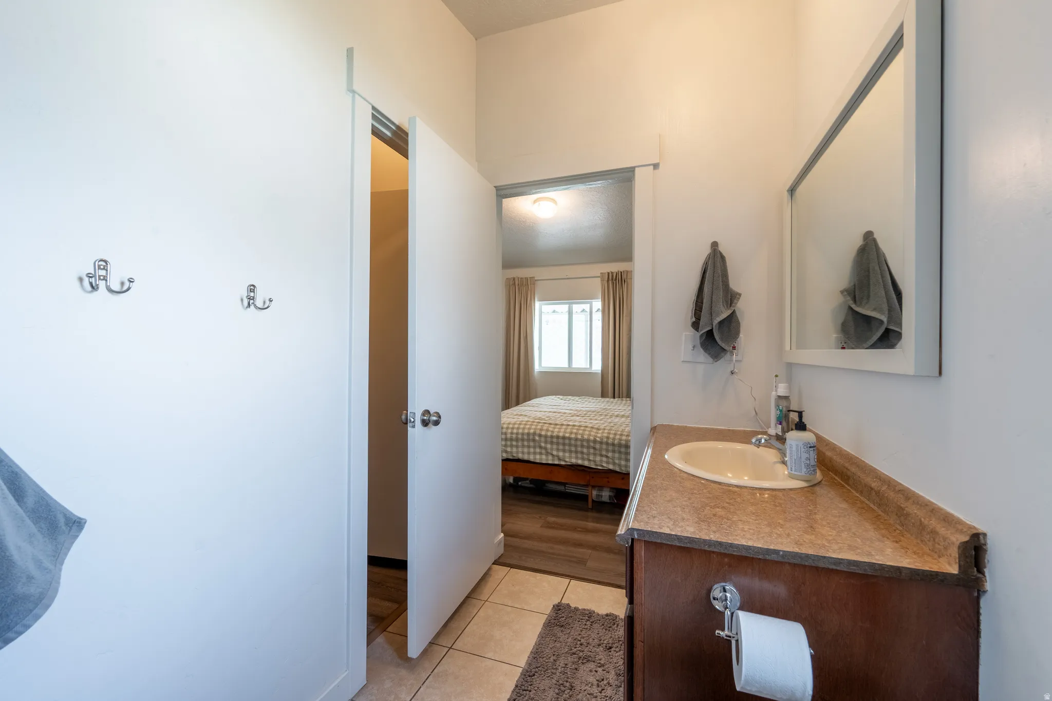 Ensuite bathroom with vanity and light tile patterned floors