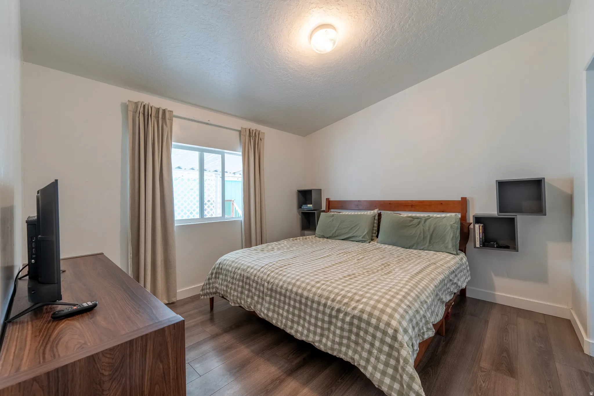 Bedroom with dark wood finished floors and baseboards