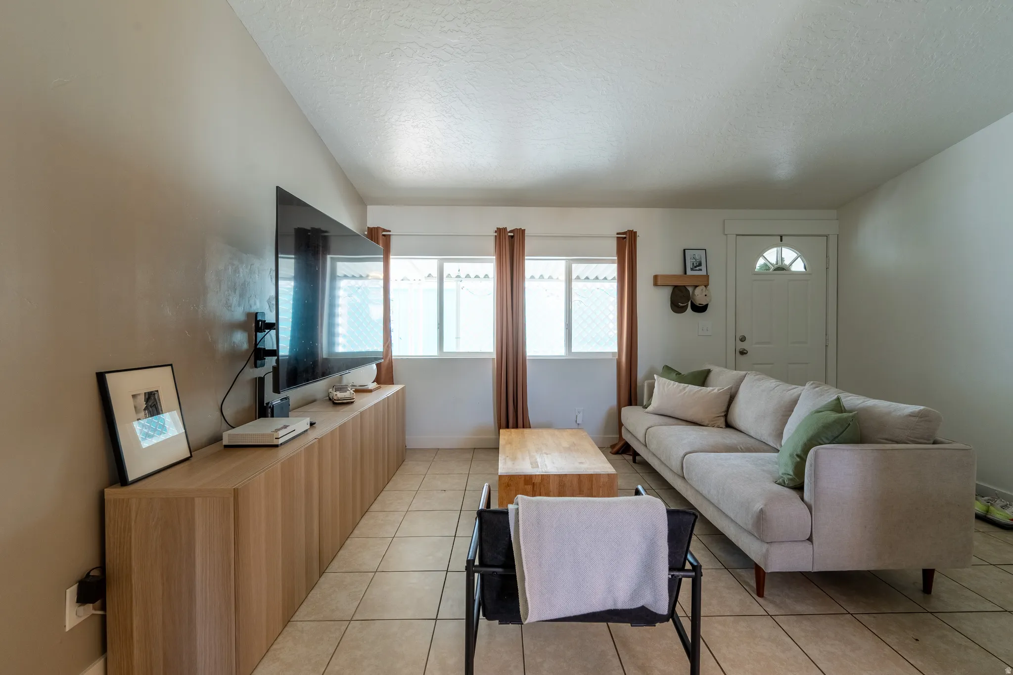 Living room featuring light tile patterned floors and baseboards
