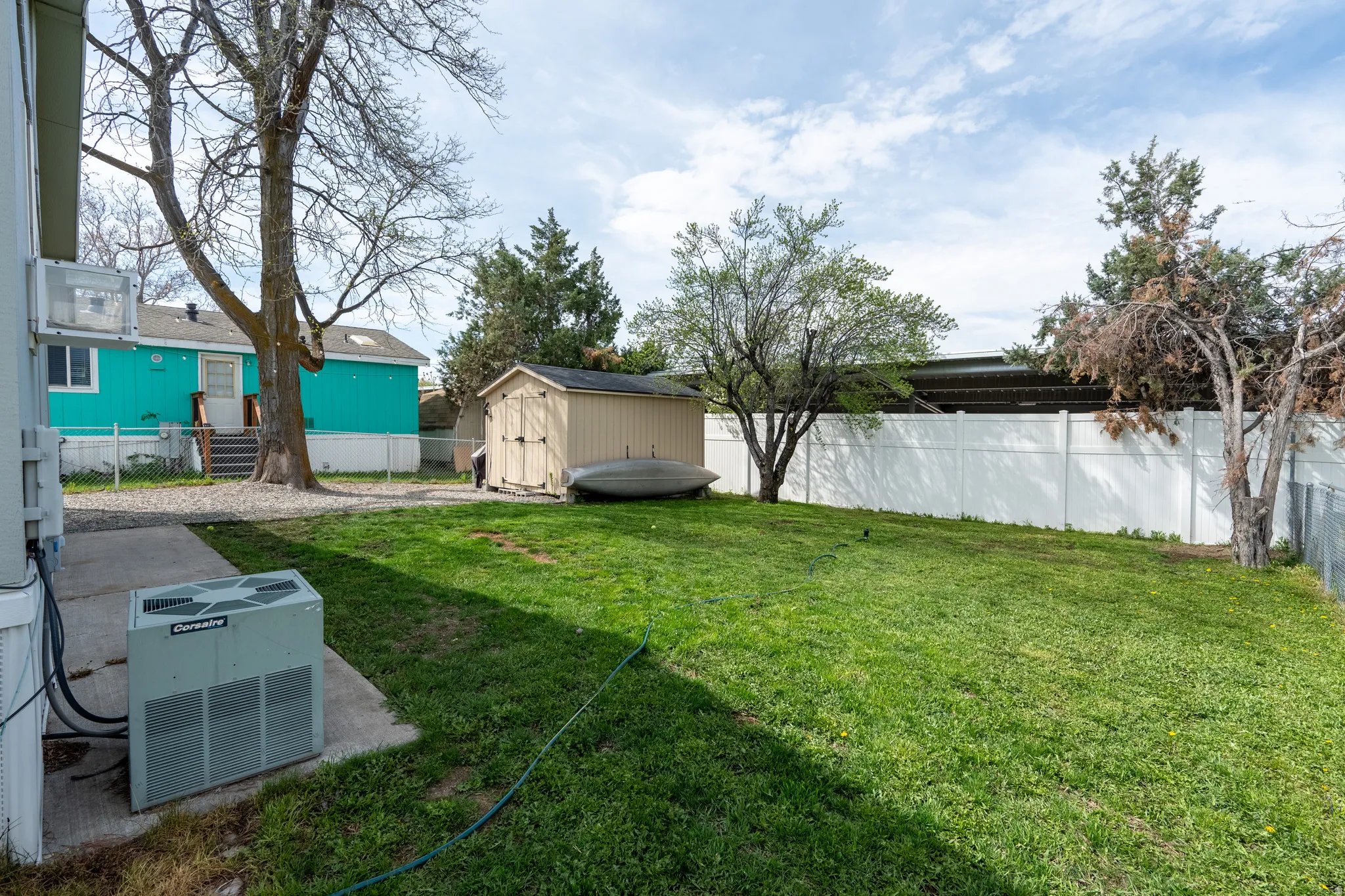 Fenced backyard with a storage shed and a patio