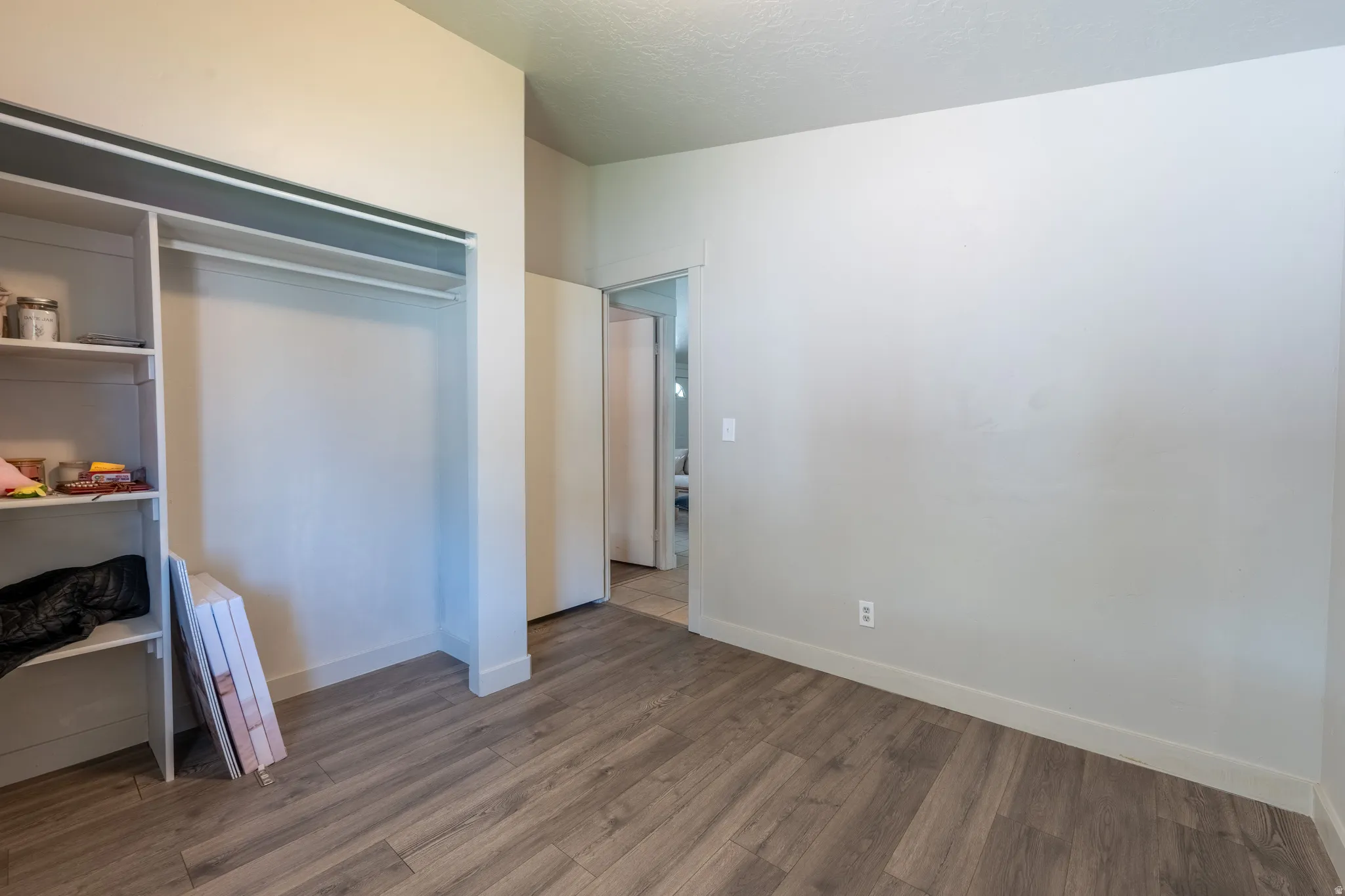 Bedroom with a closet and dark wood-style flooring