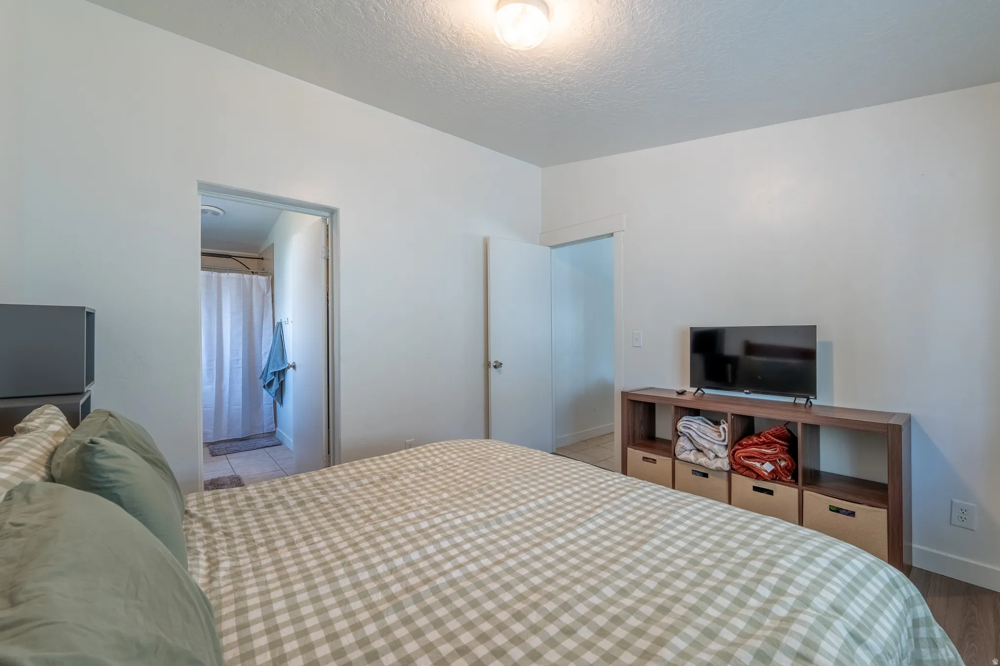 Bedroom with a textured ceiling and ensuite bath