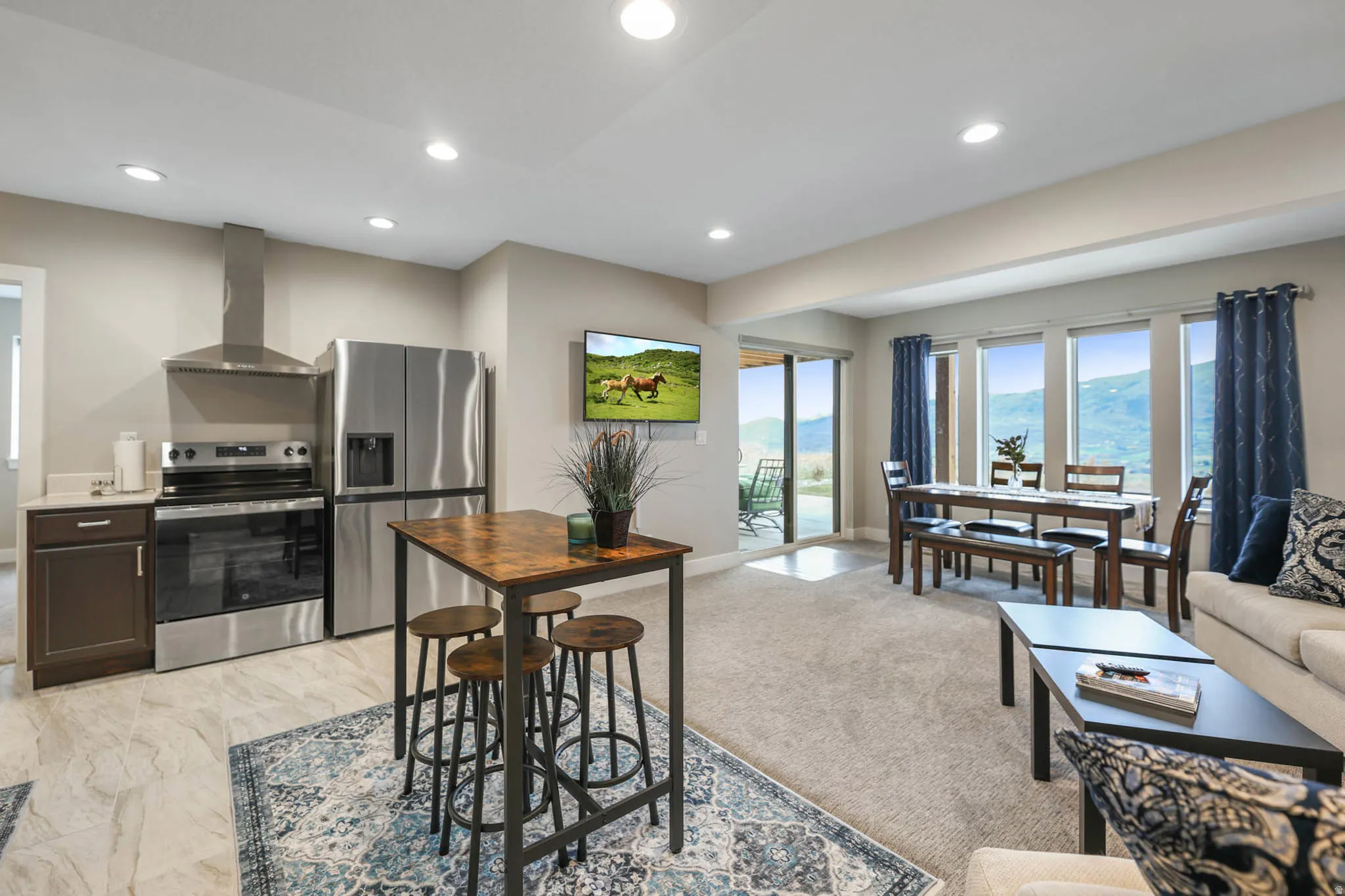Kitchen with stainless steel appliances, dark wood finish cabinets, light countertops, recessed lighting, and open floor plan