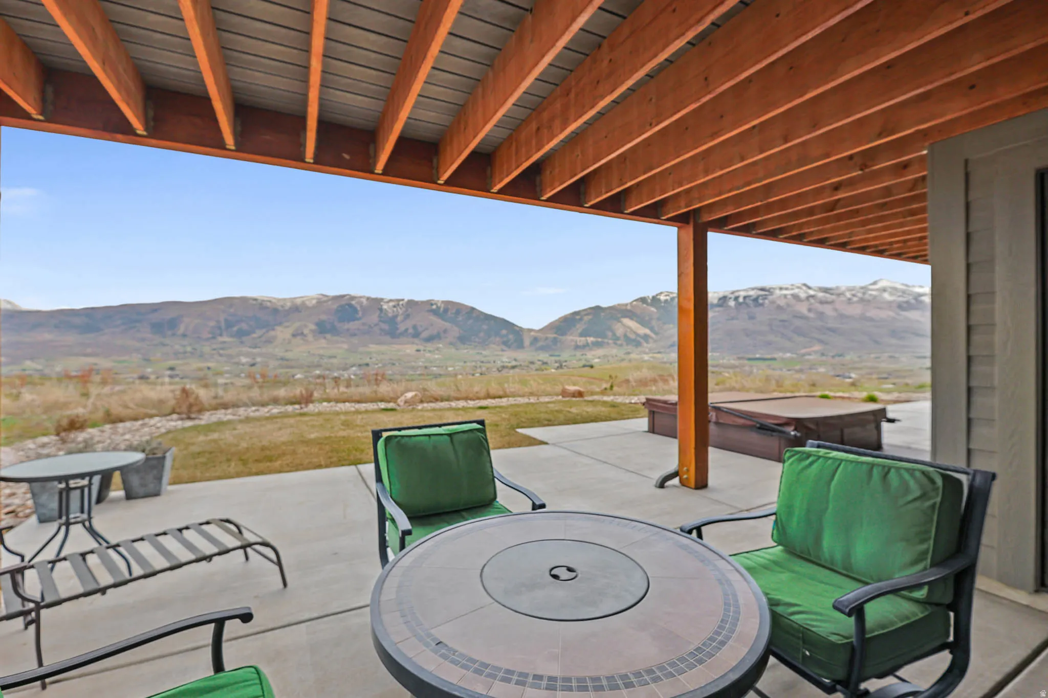 View of patio / terrace with a hot tub and a mountain view