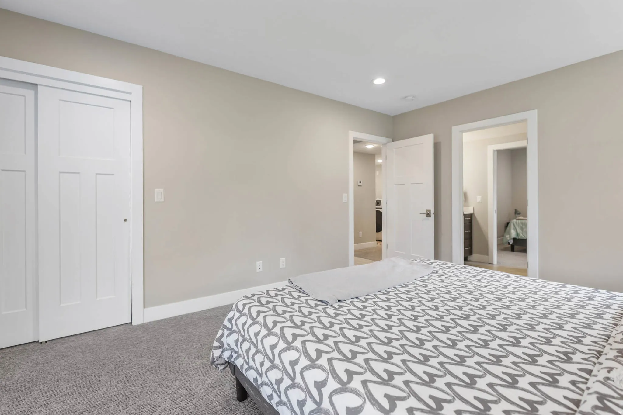 Bedroom with light colored carpet, recessed lighting, and a closet