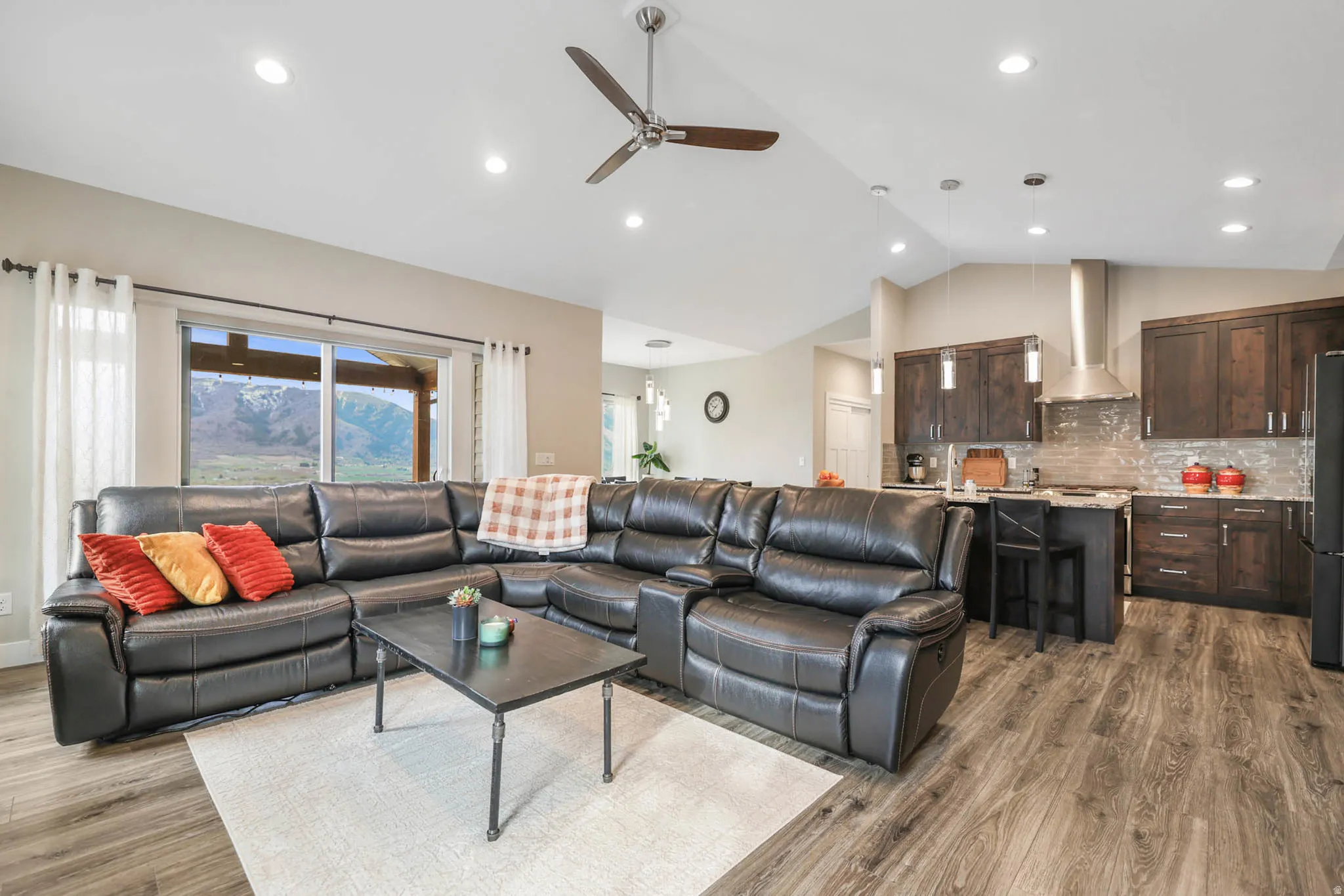 Living room featuring a ceiling fan, dark wood-style flooring, lofted ceiling, and recessed lighting