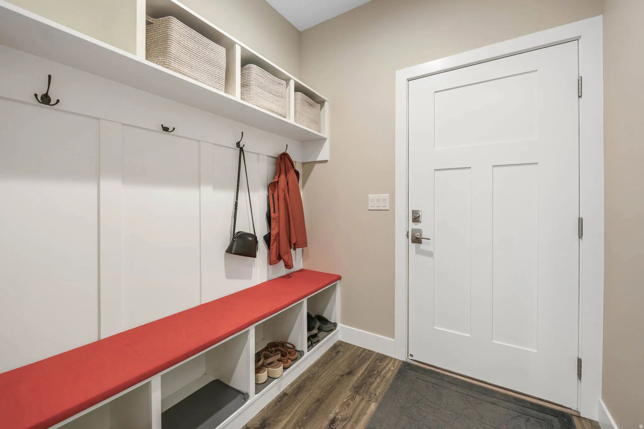 Mudroom featuring dark wood finished floors and baseboards
