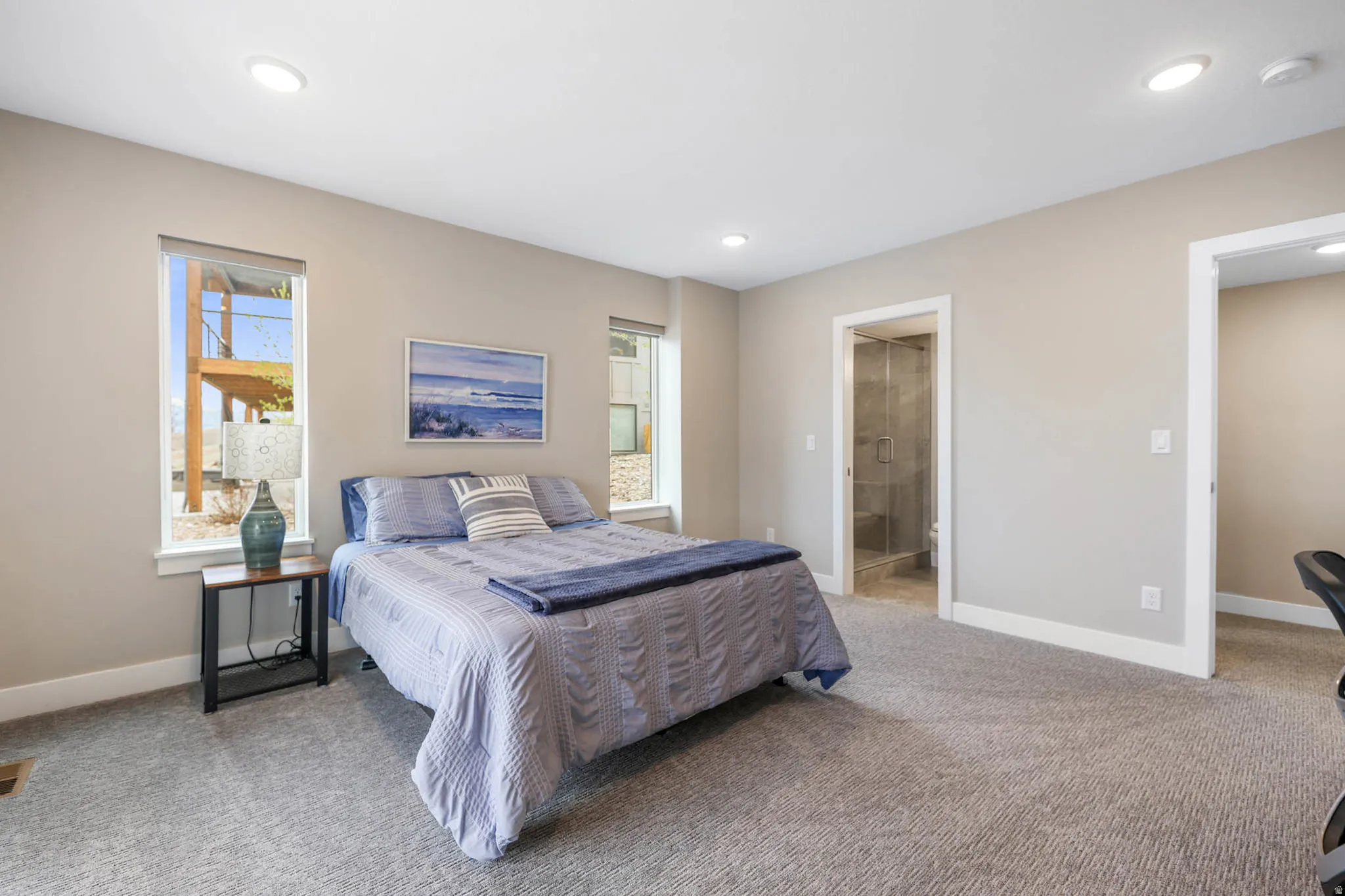 Bedroom with light colored carpet, ensuite bathroom, and recessed lighting