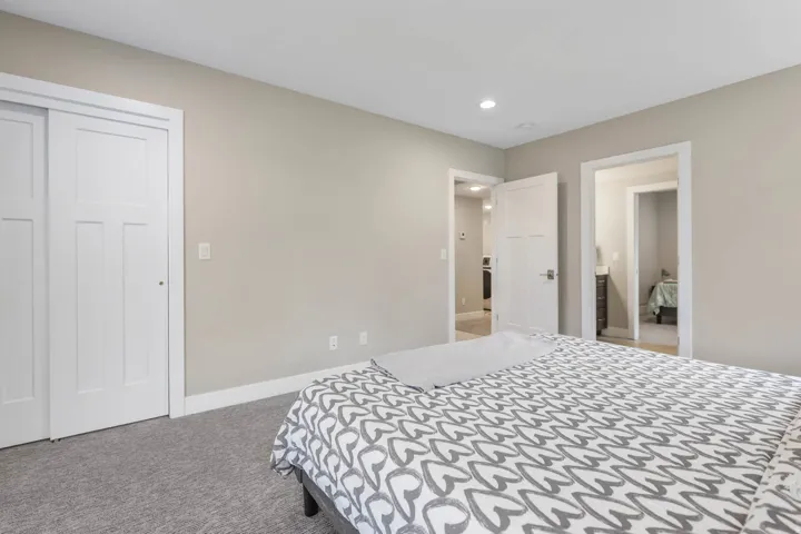 Bedroom with light colored carpet, recessed lighting, and a closet