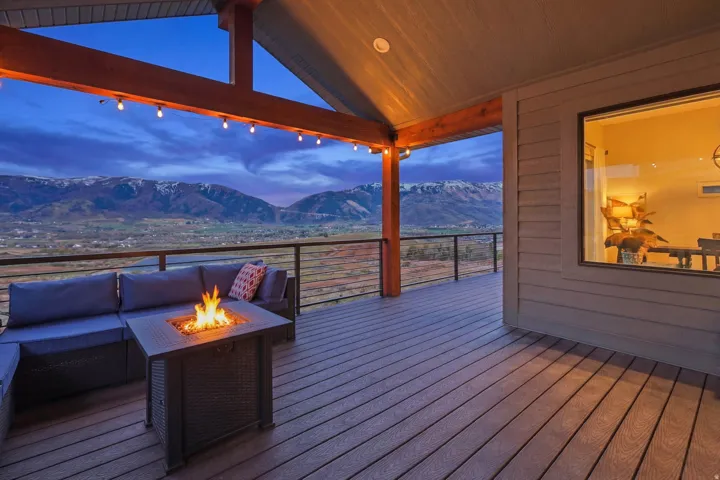 Deck at dusk with a mountain view and an outdoor living space with a fire pit