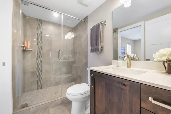 Bathroom with vanity, a shower stall, and light tile patterned flooring