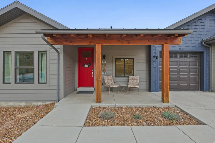 View of exterior entry featuring covered porch, a garage, and concrete driveway