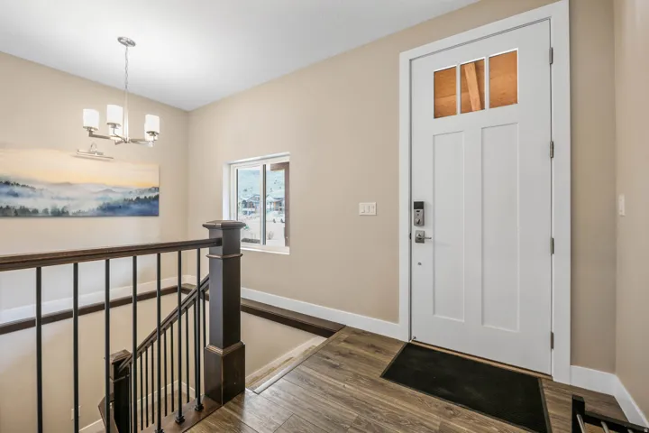 Foyer entrance with dark wood finished floors and a chandelier